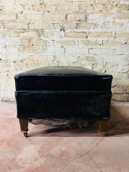 Vintage leather ottoman on wheels.